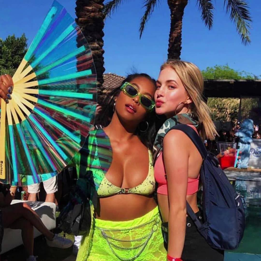 Two festival friends posing with holographic Daftboy clack fans