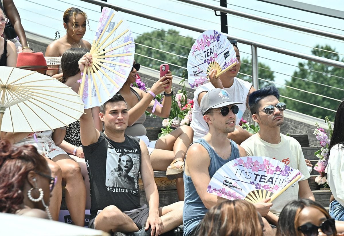Guests waving Daftboy It's Tea Time fans at the Real Housewives of Potomac event