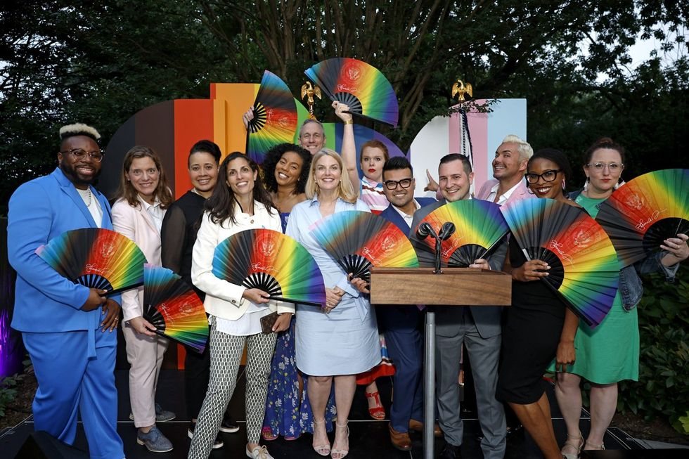 Guests at a Pride reception holding custom Daftboy rainbow fans