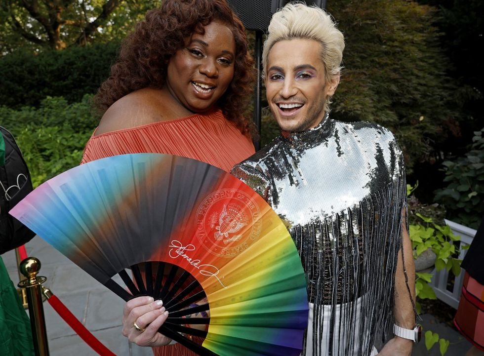 Guests at the Vice President's Pride reception with a Daftboy rainbow fan